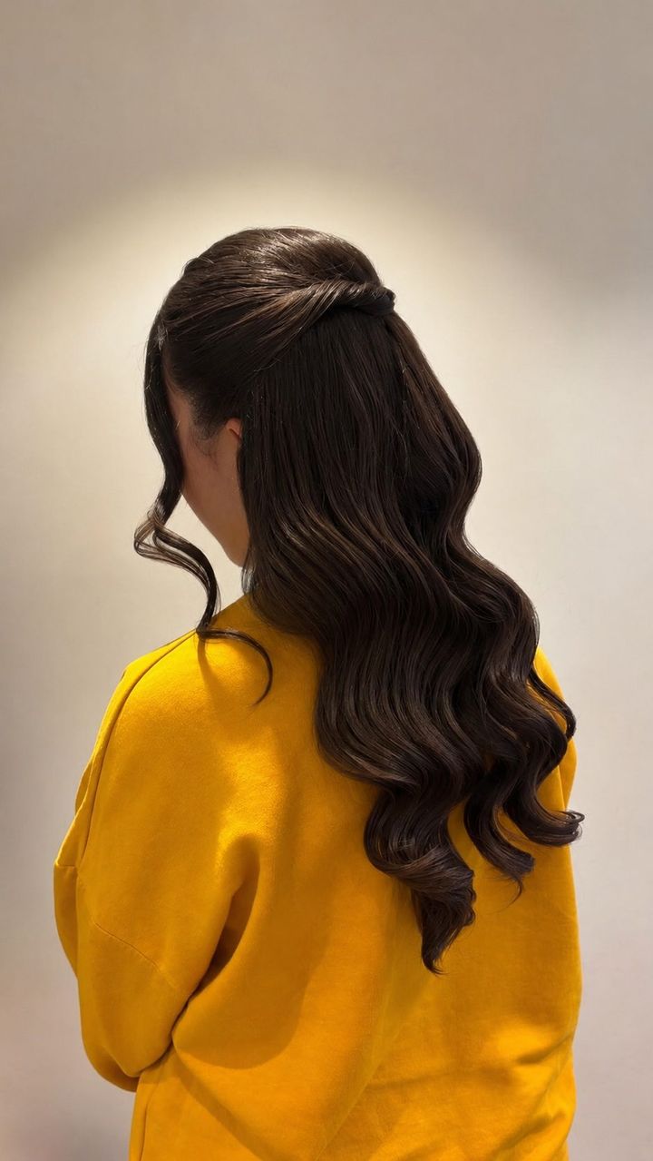 Coiffure événementielle réalisée au salon — ondulations et demi-queue